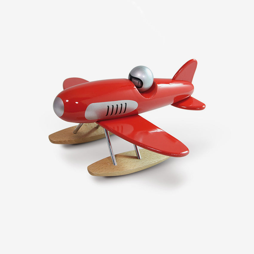 Red toy airplane with wooden wings on a white background